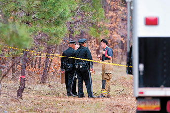 A firefighter speaks with New Mexico State Police at the scene of a crime Monday evening on Danoff Road near McGaffey in the Zuni Mountains. © 2011 Gallup Independent / Brian Leddy 